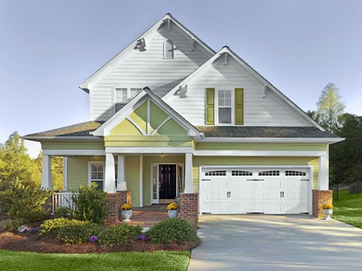 Double white wood garage door on a light yellow residential home
